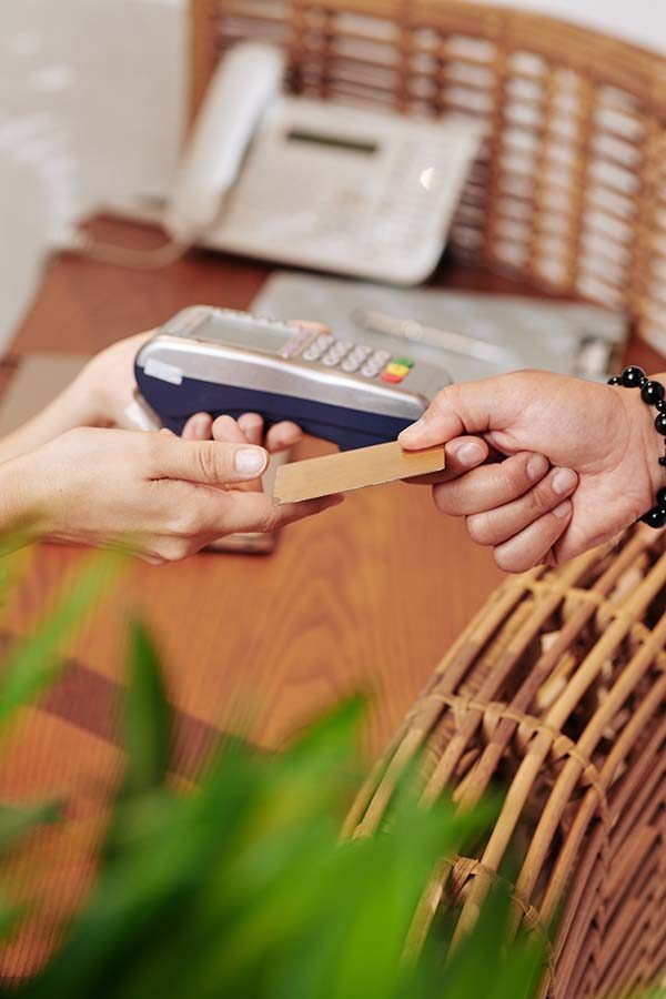 Close-up image of man giving credit card to receptionist to pay for service, spa massage or hotel room